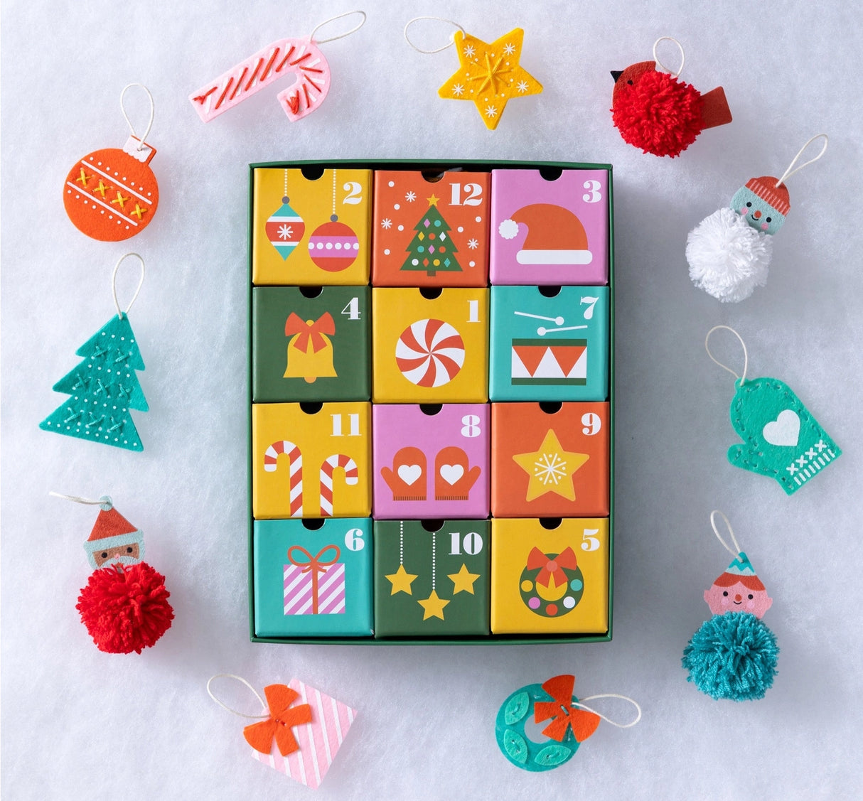 Craft your way to Christmas with the 12 Crafts of Christmas Advent Calendar. Countdown to December 25th with a daily craft surprise! Inside each of the twelve drawers is a fun and easy festive project a child can complete independently, or you can share the experience together.
Every day, a little one can slide open one of the drawers to reveal a felt or pom-pom activity.