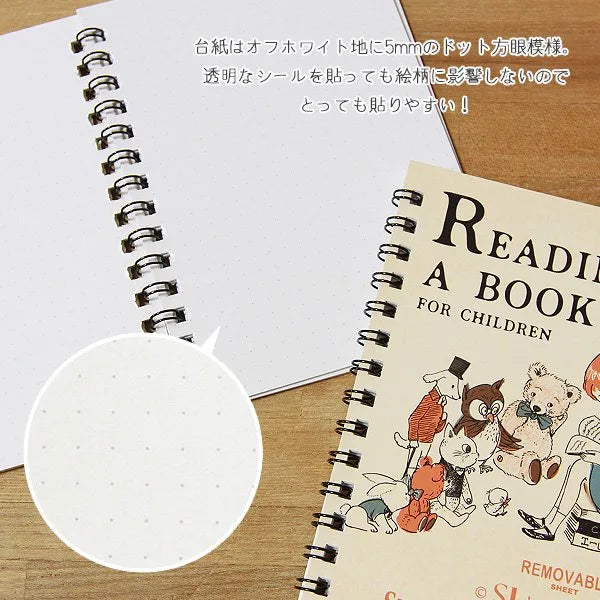 Álbum de pegatinas con la frase "Leyendo un libro" Diseño de Shinzi Katoh