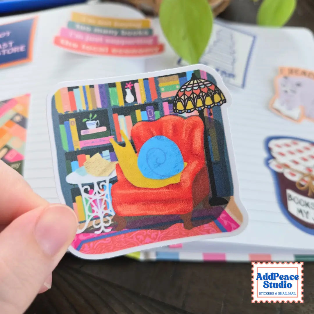 AddPeace Studio - Reading Snail Vinyl Sticker
This illustrated sticker features a snail settled into a wingback chair, surrounded by shelves of books and warm lamplight, completely lost in a letter. It captures that quiet, immersive feeling of disappearing into the analog world and not wanting to come back.
Details:
Size: 2.5"
Material: Waterproof, scratch-resistant matte vinyl
Made in USA, original artwork by AddPeace Studio