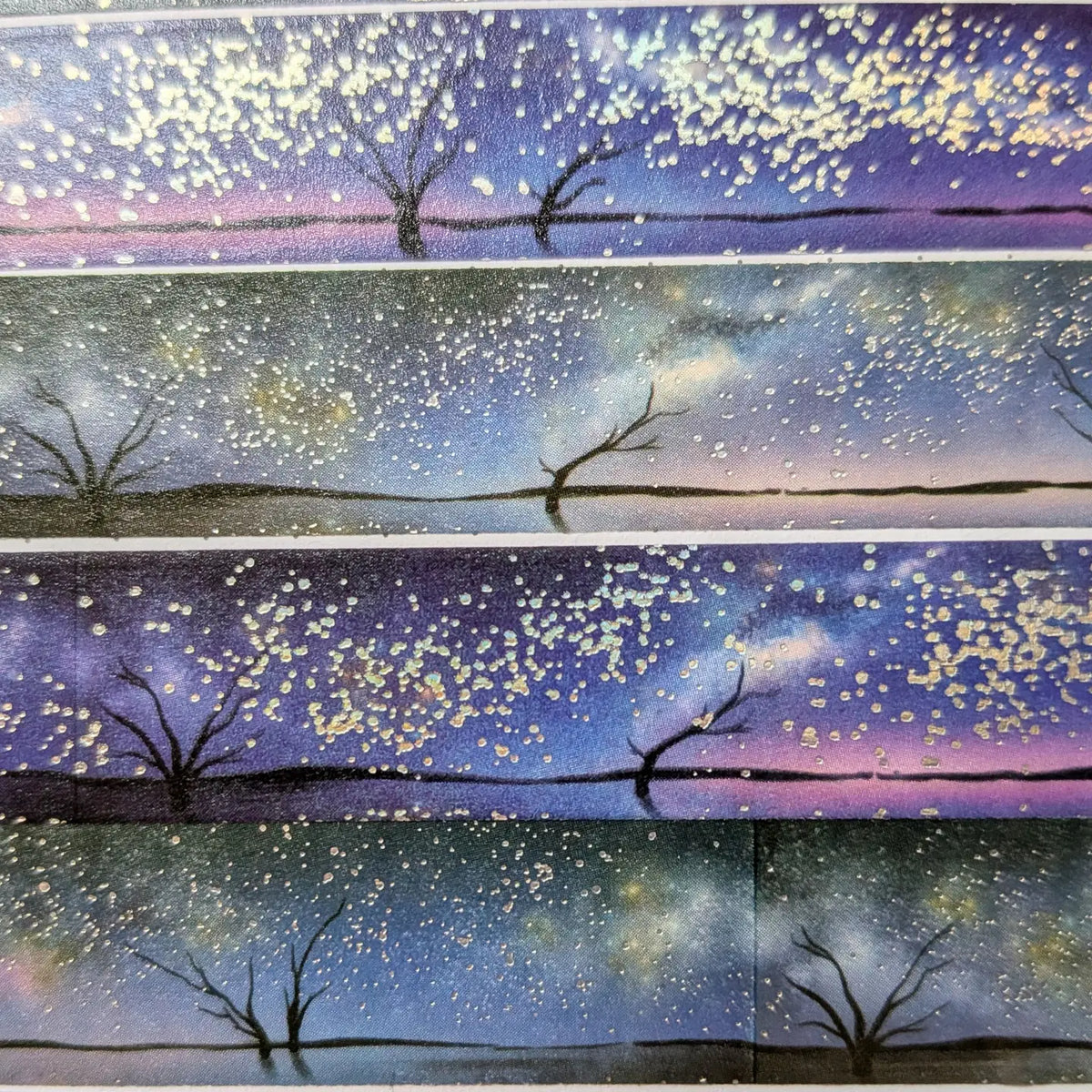 AdrianSlothArt - Holographic Foil Galaxy Washi Tape
Dreamy washi tape with holographic foil stars featuring a landscape with the milky way, tree silhouettes, and water reflections.
Details:
15 mm x 10 m
holographic foil washi tape
There are 2 versions of this design. This listing is for the more saturated version. The second version is more desaturated and has slightly darker colors.