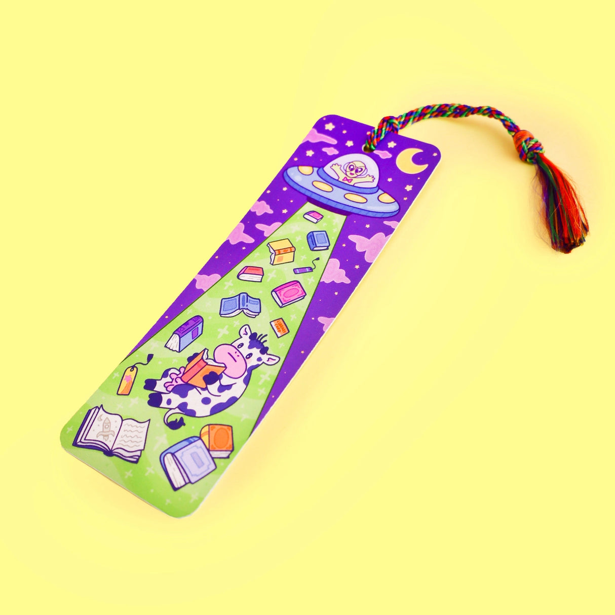'Alien Abduction Bookmark by Turtle's Soup. Libraries beware! This nerdy alien is abducting every book in town! He loves reading the unique stories that fill planet Earth. His abduction beam has a wide range, so he might accidentally pick up some life forms as well. Hopefully, they don’t mind reading among the stars with him!
Hold your spot in style with our fun and funky bookmark collection! Whether you prefer romance, fantasy, or science fiction, our bookmarks will fit perfectly between the pages of your
