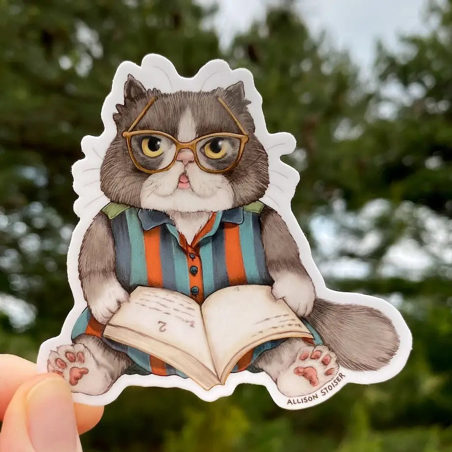 This Persian cat is settled in with a hefty tome—perhaps Purrsuastion or A Tale of Two Kitties.
This 3" die-cut gloss vinyl sticker is durable, weatherproof, and perfect for water bottles, notebooks, laptops, bikes, and all sorts of other surfaces! Make sure to clean and dry the surface thoroughly before applying.
