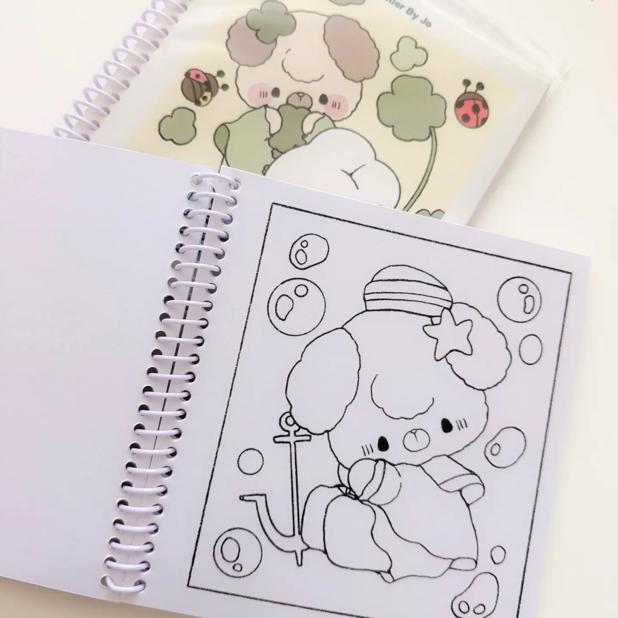 Cozy Creativity Anywhere with the Atelier by Jo Pocket Coloring Book! ✨
Bring Cotton and Pluto along on your everyday adventures with this adorable Pocket Coloring Book featuring simple and cozy Atelier by Jo character pages! Filled with 20 original illustrations in a compact 4 x 5 inch format, this spiral-bound mini coloring book is designed for relaxing, stress-free coloring anytime and anywhere.
Featuring sweet character moments, cute everyday scenes, and easy-to-color designs, this collection is perfe