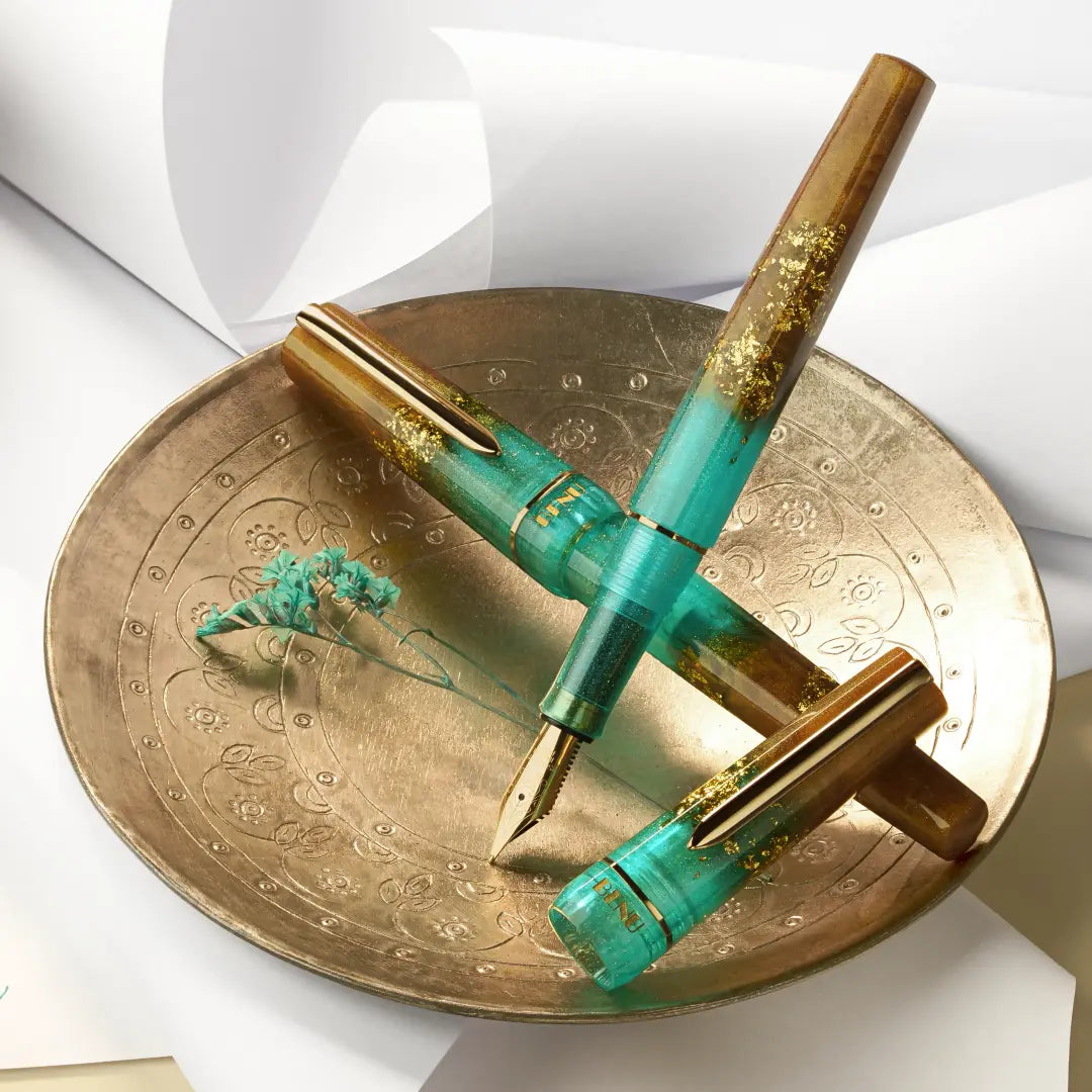 BENU presents the newest Haute Collection — a line of elegant, fashion-inspired pens that blend classic charm with bold, modern flair. The designs include both subtle and vibrant styles, showcasing BENU’s signature glitter and color artistry. Each pen features a faceted body with alternating wide and slender facets, complemented by either gold-plated or chrome-plated trims for a sleek, timeless look.
Seal and caramel tones swirl together, flecked with radiant gold. Lush evokes runway opulence — bold, textu