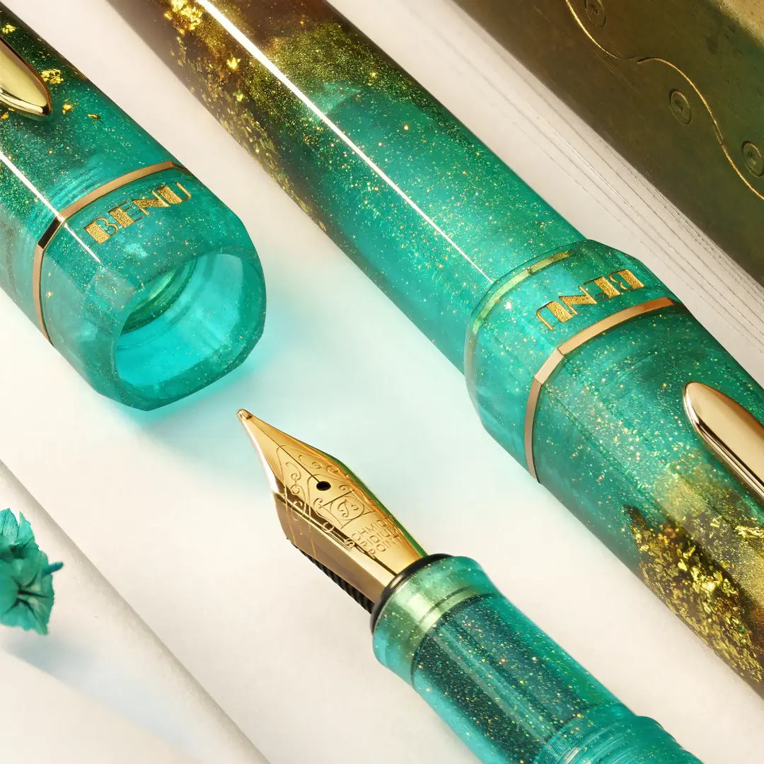 BENU presents the newest Haute Collection — a line of elegant, fashion-inspired pens that blend classic charm with bold, modern flair. The designs include both subtle and vibrant styles, showcasing BENU’s signature glitter and color artistry. Each pen features a faceted body with alternating wide and slender facets, complemented by either gold-plated or chrome-plated trims for a sleek, timeless look.
Seal and caramel tones swirl together, flecked with radiant gold. Lush evokes runway opulence — bold, textu