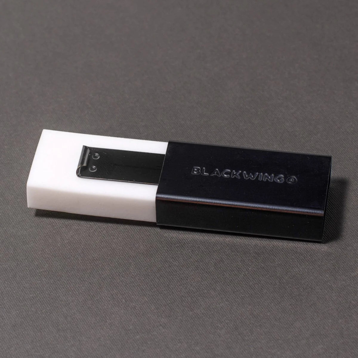 We took the iconic design of our eraser clip and adapted it into a sleek handheld form that feels great to use.
The eraser is made of a special soft material that erases the dark lines of our graphite cleanly and easily. The holder is made of durable aluminum that lets you get a solid grip while erasing. It also includes a jumbo-sized version of the iconic Blackwing clip, so you can extend the eraser as you use it.