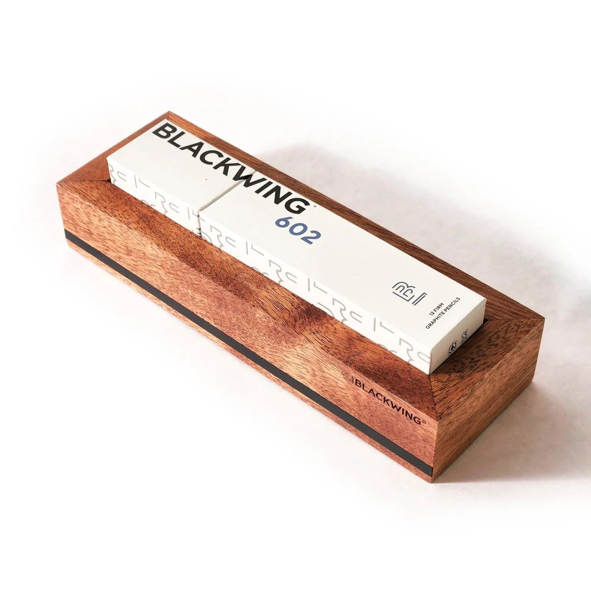 Put your favorite Blackwing 12-pack on display. This mahogany, solid wood pencil display is designed to showcase a single 12-pack Blackwing pencil box in a flat-lay position. Its clean, premium, and minimalist profile fits perfectly on every desk, shelf, or wall using the predrilled mounting holes. The Blackwing logo is engraved on the side.
The Blackwing Flat Box display measures 9.8125 x 3.25 x 1.75 inches.