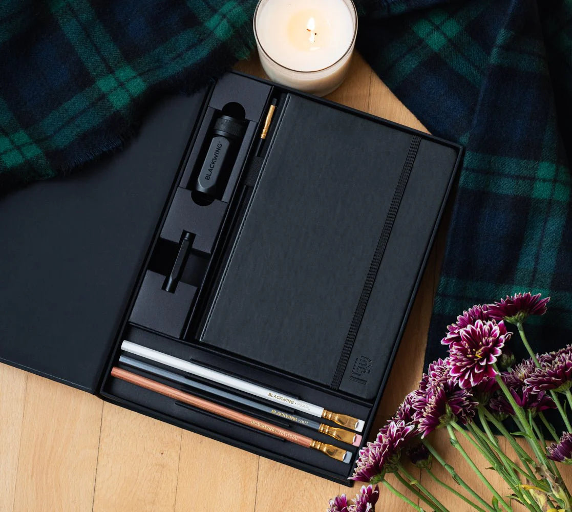 A great way to get started on the Blackwing journey. Give the gift of high-quality Blackwing pencils, paper & accessories — all in one box set.
Includes a Medium Black A5 Slate Notebook, each of our core pencils (602, Matte, Pearl, Natural), One-Step Long Point Sharpener, and Point Guard -- all packaged in a box set.