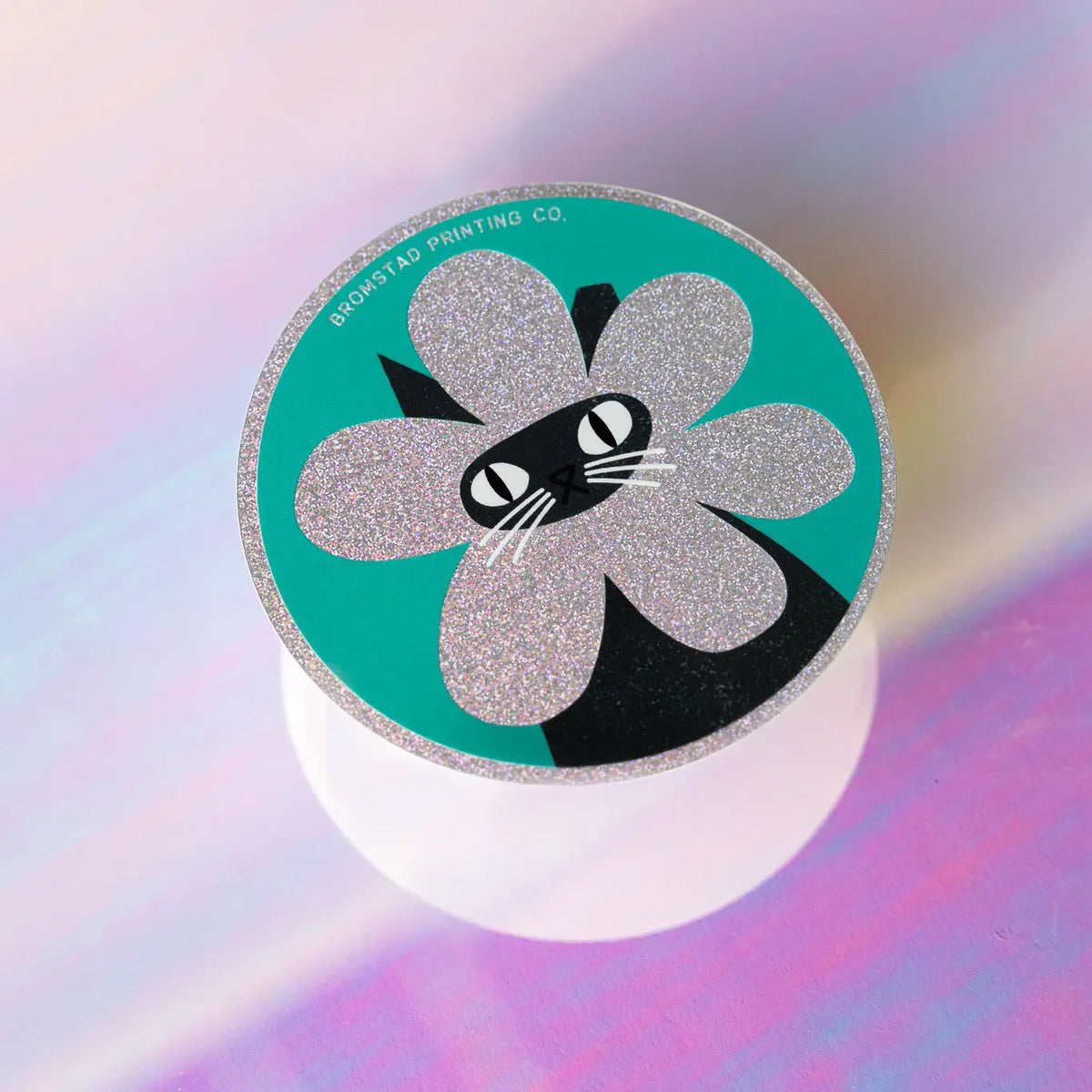 Product description
A black cat with a clipped ear wears a sparkly flower around their face. Truly, the rarest bloom. This 3" super sparkly glitter sticker is purrfect for adorning water bottles, laptops, and more. Watch how it catches the light!