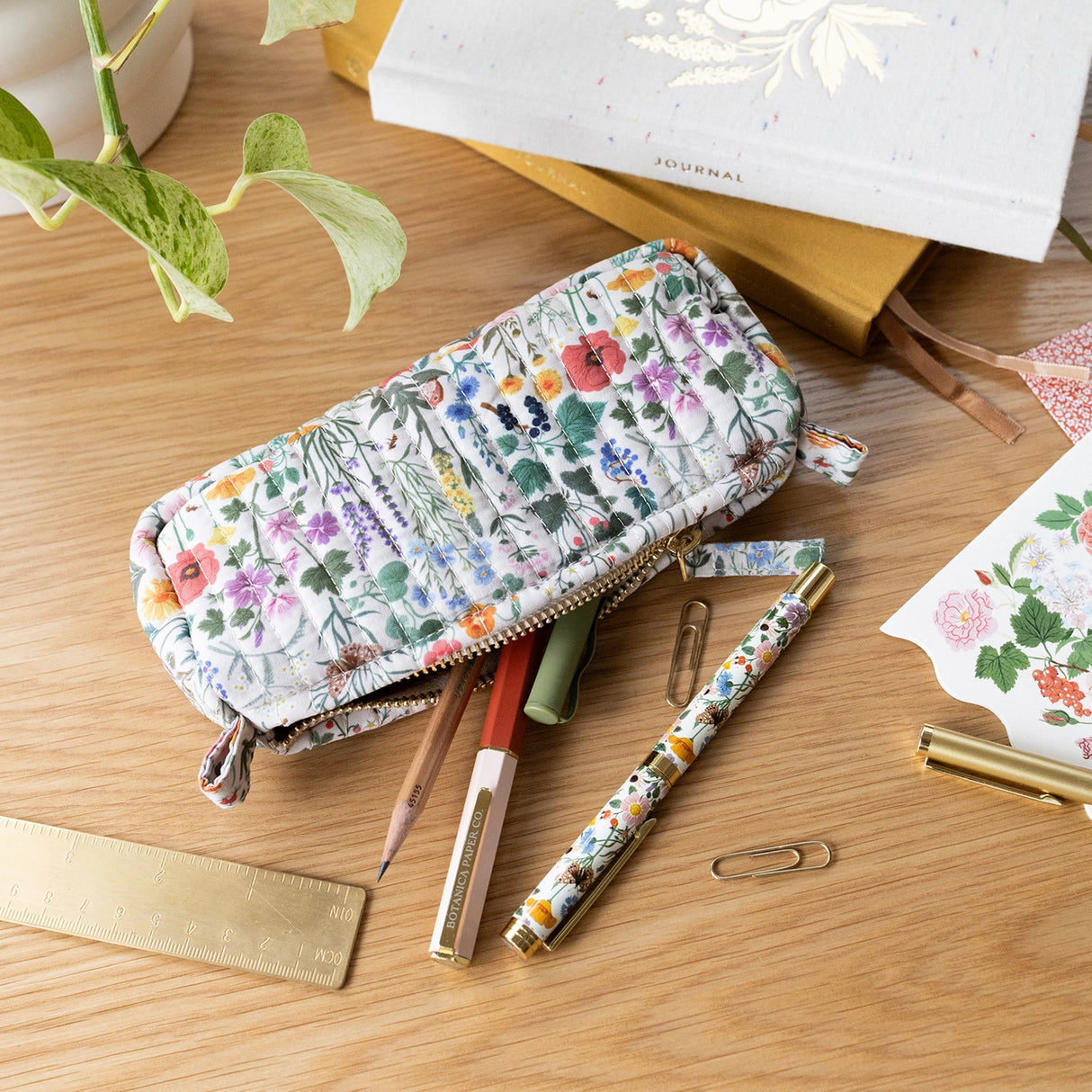 Each versatile pouch showcases premium quilted cotton in four distinct illustrated patterns, complemented by an elegant gold brass zipper with coordinating pull—adding a sophisticated finishing touch to these signature pieces.
Features:
Size: 7" x 3" x 2"
Premium quilted cotton exterior
Coordinating interior cotton lining
Gold brass zipper with matching pull
Versatile use as pencil pouch or makeup bag
Perfect for desk display or on-the-go organization