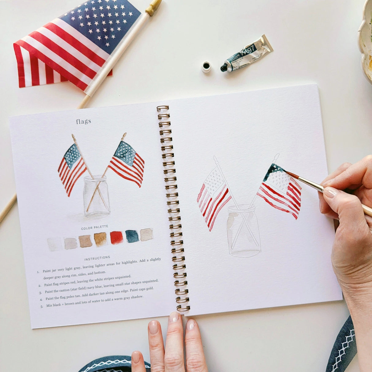 Twelve illustrations of flags, stars, and classic summer scenes — each pre-outlined with step-by-step instructions. Paintings take about thirty minutes from start to finish, making it approachable for first-time painters and a favorite for gifting.
A timely release for America's 250th anniversary in 2026. A strong May–July seller and a natural fit for home, gift, and patriotic-themed boutiques.
12 beginner-friendly illustrations
Thick 120lb watercolor paper
Lay-flat pages with spiral binding for has