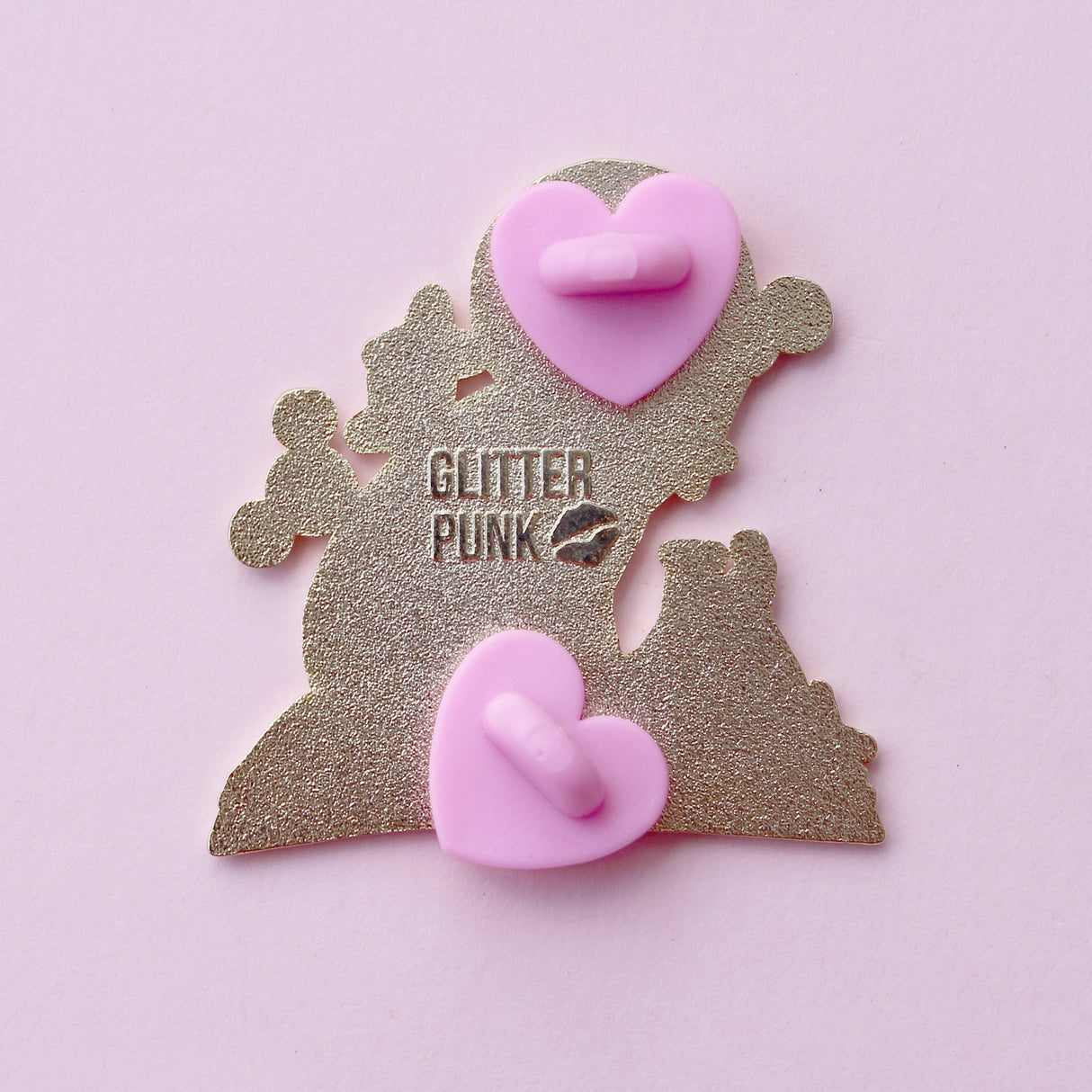 If you’re passionate about science and partial to cats, this awesome pin is perfect for you! It features a black cat sitting on a book and playing with atom parts. It also features a glittery moon and two beakers filled with purple liquid.
The pin is 42mm (1.65”) tall, and is made from gunmetal hard enamel, with glitter and UV printed details. It's secured with 2 pink clutches to keep the pin in place.