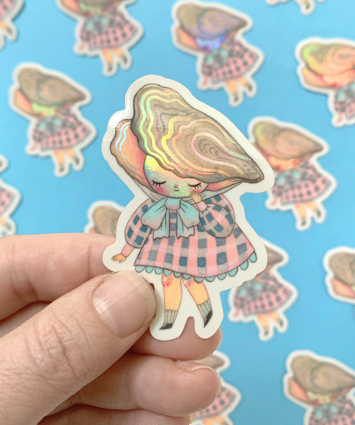 "Pearl" Vinyl Sticker made from Hannakin illustration with subtle holographic accents (on the face and oyster shell) with shiny gloss finish.
Made from a durable waterproof vinyl with a matte laminate that protects it from scratching, rain and sunlight.