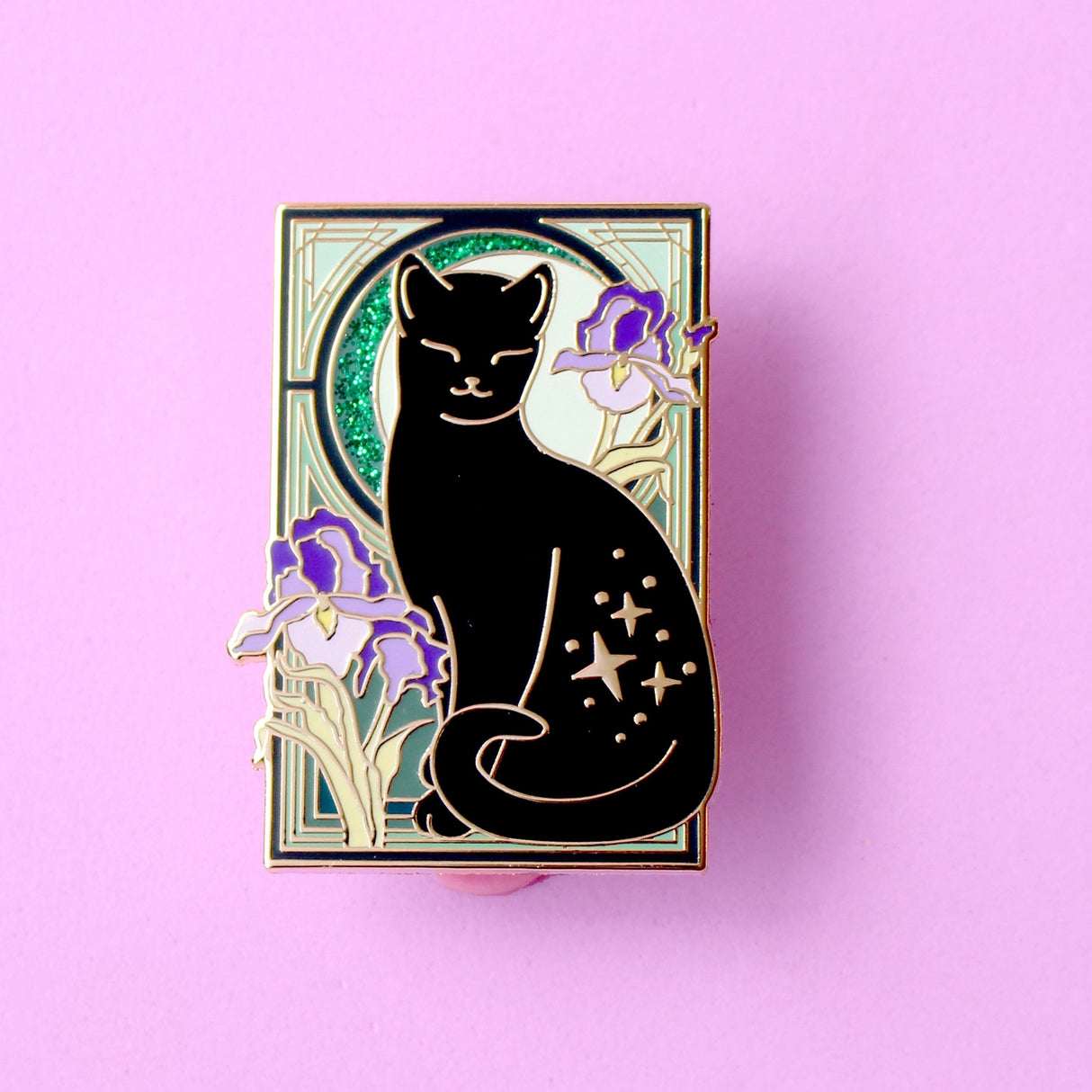 This cute Iris Cat enamel pin features a sweet black cat surrounded by iris (flag) flowers, in front of a glittery moon set against an ornamental green art nouveau background.
The pin is secured by two purple heart backs and comes on a special ‘Art Nouveau’ Glitter Punk backing card, making it perfect for a gift or to keep as a special treat for yourself.
This pin is part of my Art Nouveau Cats collection – 8 enamel pins based on the fabulous 19th/20th century art movement. Check out the full collection a