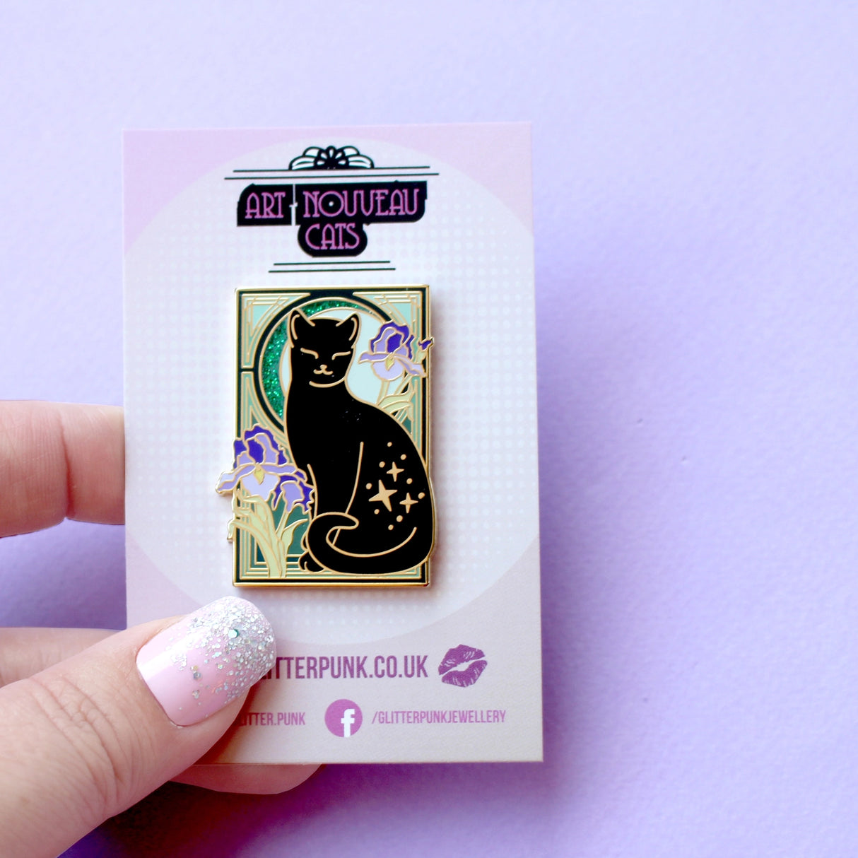 This cute Iris Cat enamel pin features a sweet black cat surrounded by iris (flag) flowers, in front of a glittery moon set against an ornamental green art nouveau background.
The pin is secured by two purple heart backs and comes on a special ‘Art Nouveau’ Glitter Punk backing card, making it perfect for a gift or to keep as a special treat for yourself.
This pin is part of my Art Nouveau Cats collection – 8 enamel pins based on the fabulous 19th/20th century art movement. Check out the full collection a