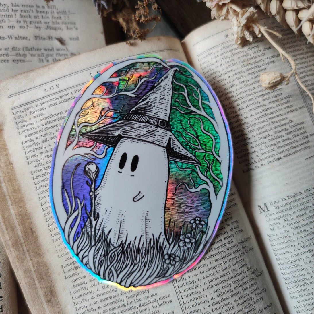 A magical ghostie on a shiny cosmic sticker, from my original artwork.
Die-cut vinyl holographic sticker, suitable for interior or exterior use; perfect for a phone, laptop, car, planner, or wherever you want to put a shiny robot. Measures approximately 7.5cm (3 inches) at its widest point. Difficult to photograph, but it shimmers beautifully under the light with an exciting oilslick rainbow effect.
