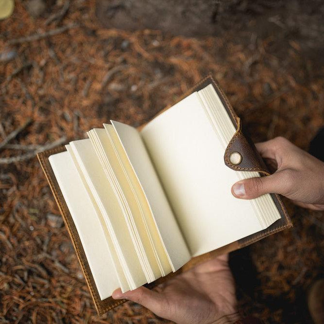 Kodiak Leather Drifter Leather Journal
The Drifter Leather Journal is designed for travelers, writers, and creatives who appreciate quality craftsmanship and timeless style. Made from top-grain leather, this beautifully crafted journal features a secure snap-button closure and handmade artisan paper, making it an ideal gift for adventurers and homebodies alike.
With 210 blank pages and a refillable design, it’s perfect for capturing thoughts, sketches, or travel memories. Measuring 7” x 5” x 2.5”, the Dri