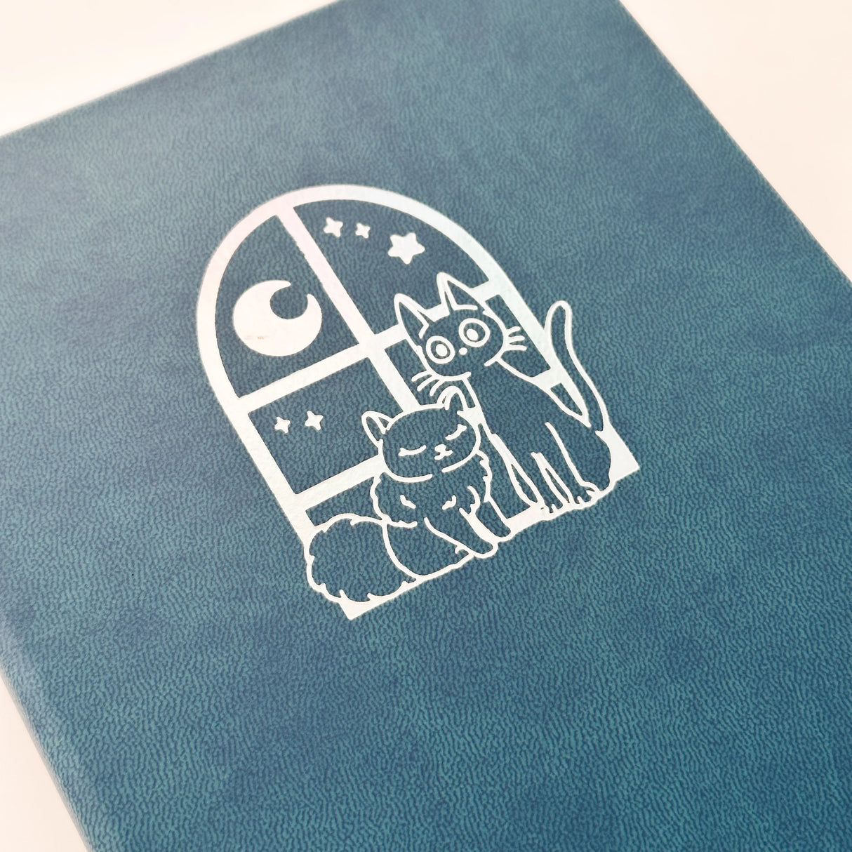 Jiji The Cat Journal in Ocean Blue with Holographic Edges and Logo 🌊✨
Product Details:
Size: A5 (5.70 x 8.26 inches)
160 Dotted Grid Pages (5 x 5 mm)
2 Bookmarks
Elastic Band and Pen Holder
Expandable storage compartment