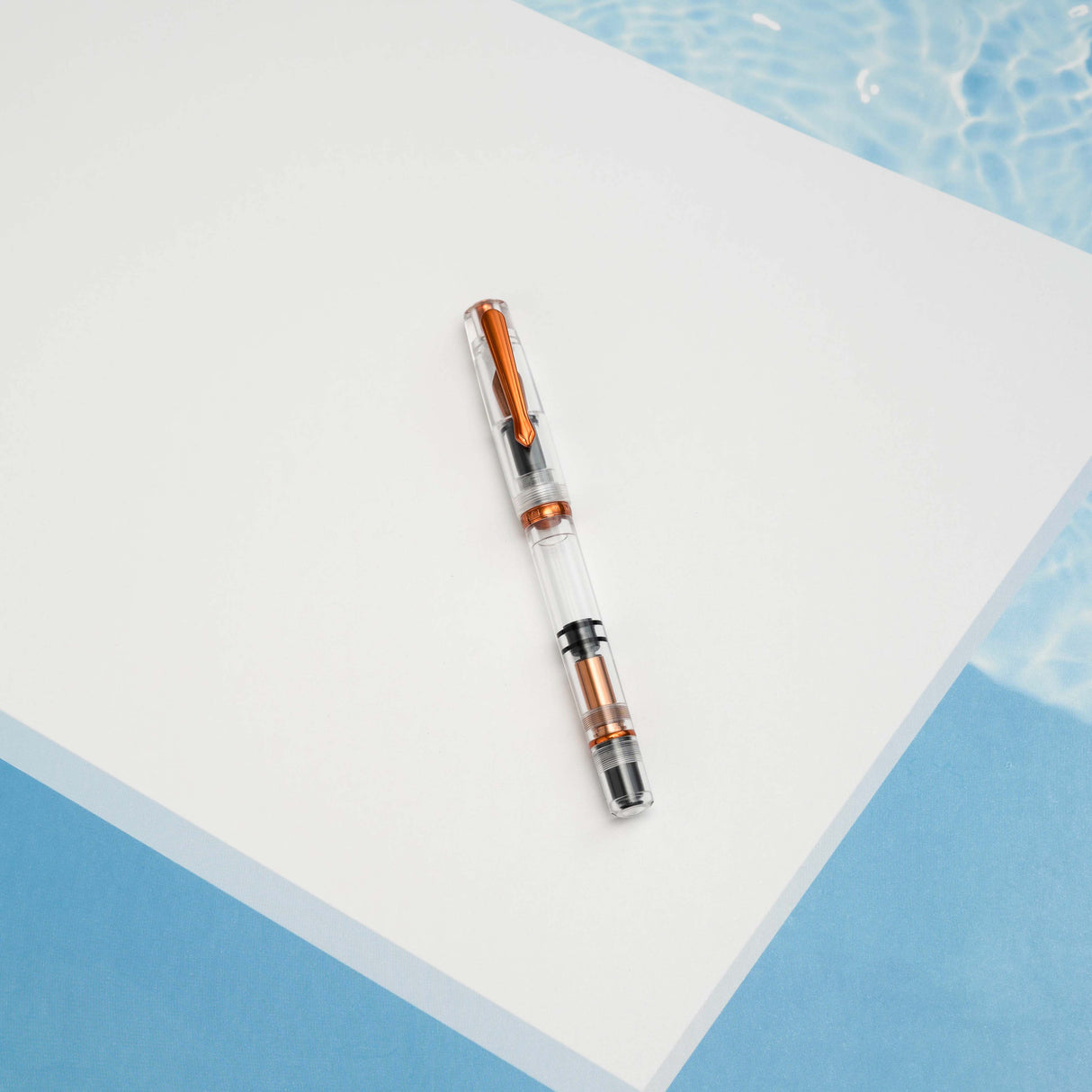 The Original: Summer follows in the footsteps of the provenly popular Original: Spring. Made out of a clear acrylic, the only colored parts of the pen are the: clip, ring, piston and nib. These components have been plated in a bright coppery orange. As always, the Original: Summer uses our in house stainless steel nibs and this demonstrator has a full view of the piston filling system.
