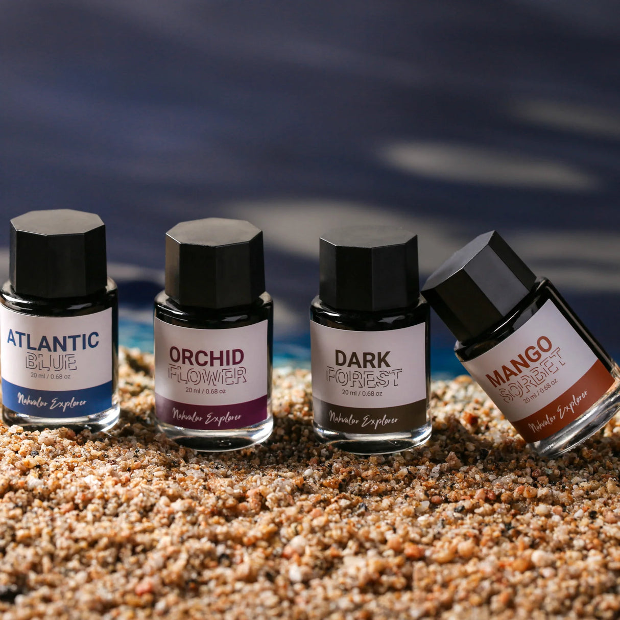 The new Nahvalur Explorer ink collection is comprised of four fountain pen inks—Dark Forest, Atlantic Blue, Orchid Flower, and Mango Sorbet—each inspired by one of the original Nahvalur Explorer Plus fountain pens. The box packaging features a lighthouse illustration in the ink color. The 20-ml round glass bottles have a hexagonal cap, and inks are pH neutral and fast drying.