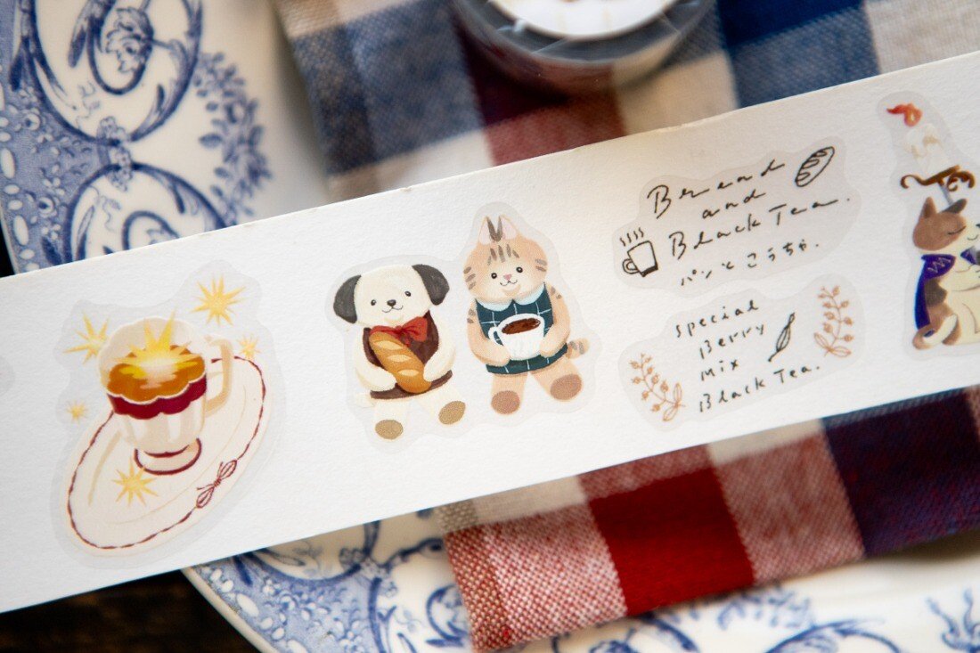 Welcome to the Tea Room! This kiss-cut PET Tape features a relaxing teahouse filled with cats and other furry friends. It adds the perfect touch of warmth to your journal pages with hints of golden brown and dark blue as conversations continue until midnight.