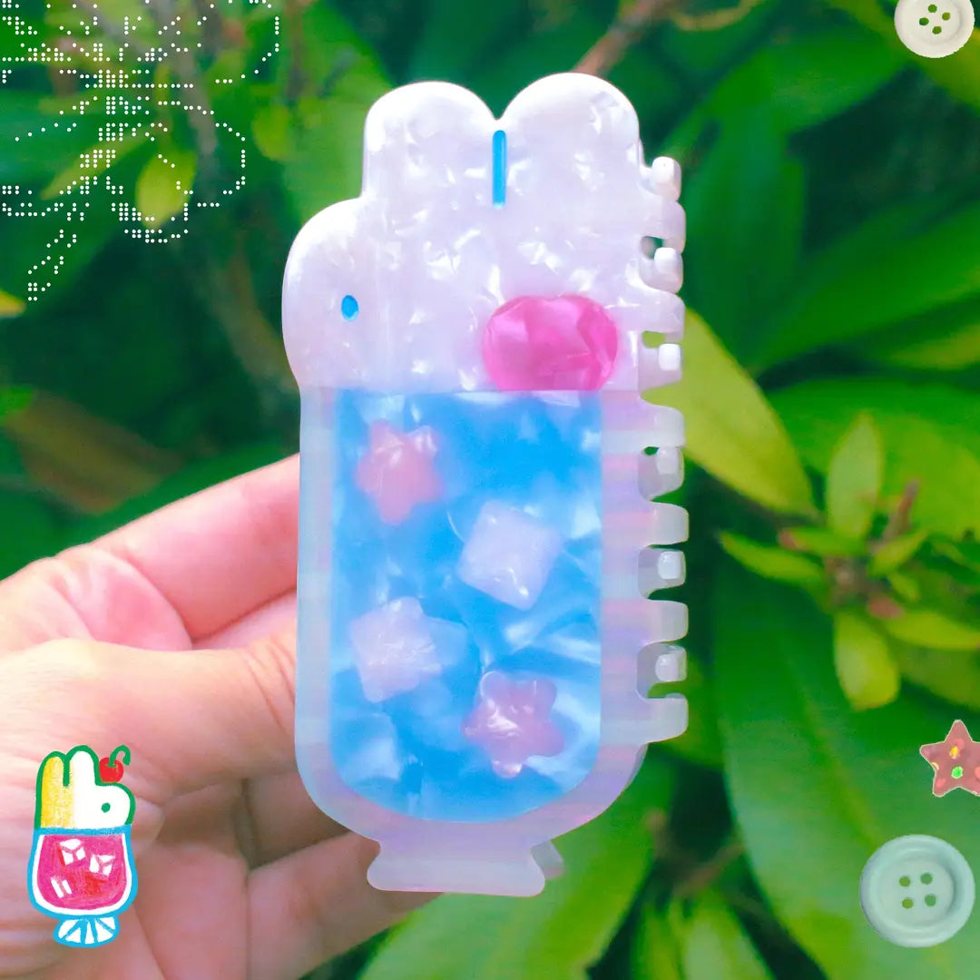 'Soda Float' Hair Claw featuring a blue soda float with rabbit shaped ice cream on top.
Made of acetate, 4 inches by 2 inches.
Hair claws come packaged in a plastic sleeve.