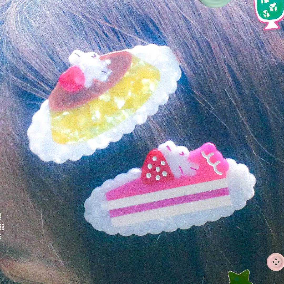 Pudding & Cake Hair Clips as a set of two clips. Clips are 2.5 inches long, made of acetate and have an alligator style clip on the back.
Clips should not be submerged in water.
Hair clips come with a backing card in a plastic sleeve.