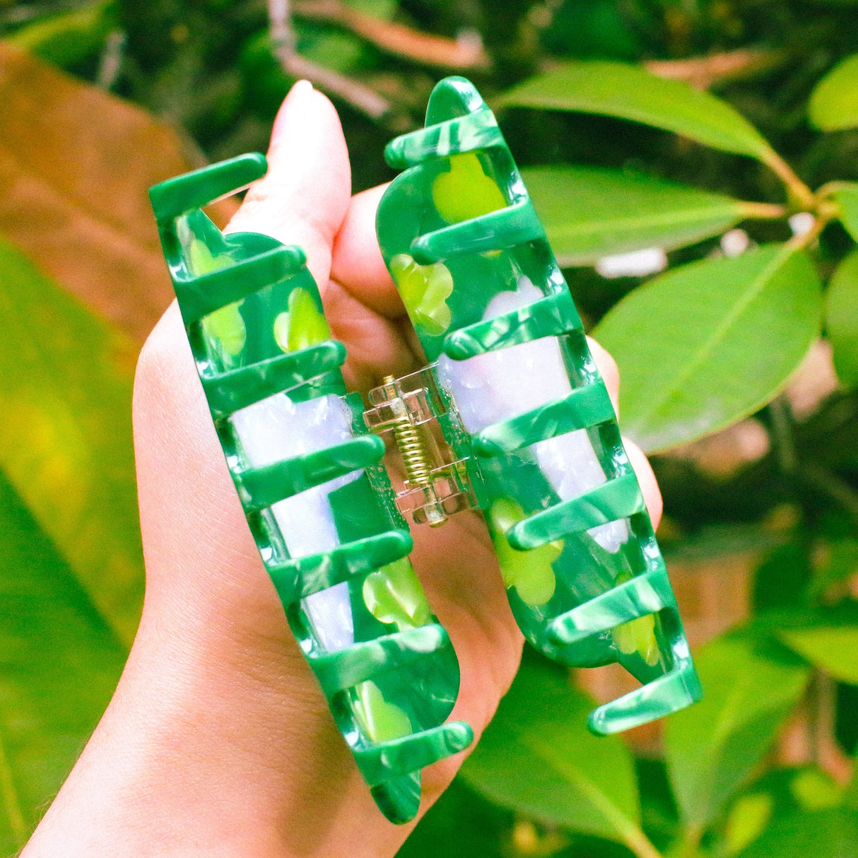Clover Hair Claw featuring a little rabbit leaping through a field of clover.
Made of acetate, 3.5 inches long. 