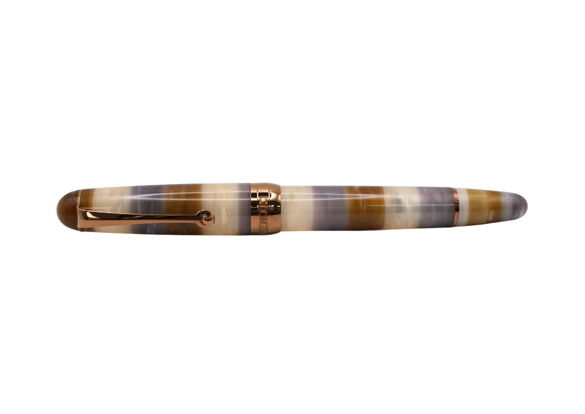 Penlux Masterpiece Delgado Bumblebee Fountain Pen
The collection of Delgado Selected is a premiere version of the Delgado which uses only rare materials and with small production quantity. The Bumblebee was created using PMMA resin and only 70 pieces were produced.
The Bumblebee Delgado features an earthy style with banded swirls of smoky slate grey, translucent honey amber, creamy white, and deep caramel. Topped off with copper plated trim and nib, it looks less like a bug and more like