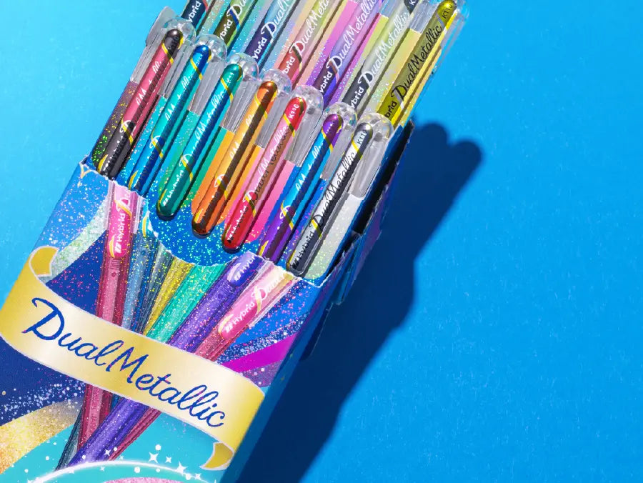 The Dual Metallic is a playful ballpoint pen with two sparkles in one line.
Because the ink and glitter colors are different, they produce colors that can be seen depending on the angle of light and the color of the background.
White paper has a delicate shimmer, and black paper has a deep, fantastic brilliance. With just one pen, you can create a variety of expressions that attract the viewer's heart.
It is finished in a set case made of paper material with a glittering hologram finish. Inside the case, t