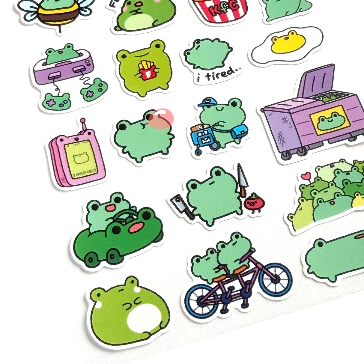 This is part of a new series of sticker sheets that feature different "days".
There are 25 individual stickers on the sheet full of FROGS.
They are vinyl stickers on a clear plastic sheet with a backing card. The bag has a hanging hole for retail display.
The whole packaging is 3.8 x 8.75" and is ready to hang.
The sticker sheet is 3.75 x 5.8"