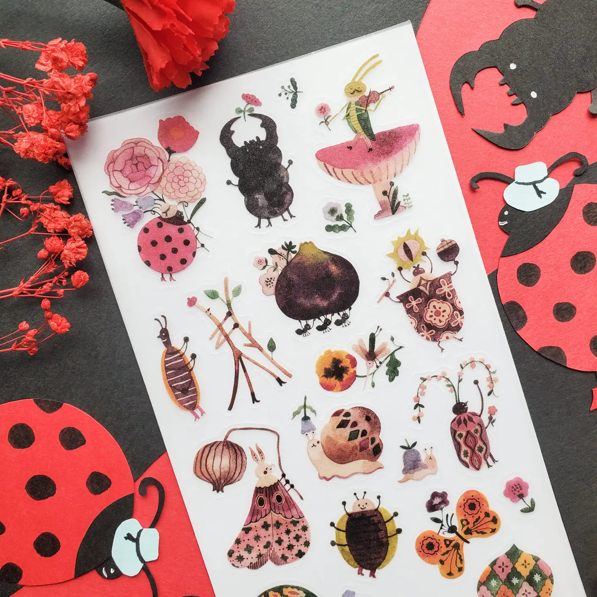 🎻🦗 Take a peek into a bug’s life with @lele_melele, where flower-crowned beetles, violin-playing grasshoppers, sleepy snails, fancy moths, and berry-toting critters are all out here living their best leafy lives. This sheet is like a secret bug party happening under the leaves and we need an invite immediately.
Art by: @lele_melele
One sticker sheet is included.
• Top Coating: None
• Adhesive Layer: Washi
• Backing Layer: Clear PET
• 6.69"x3.54"
• Weight-0.03oz
• 1 Sheet Included