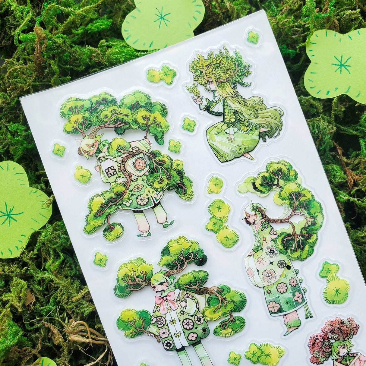🌳🍃 Get ready to branch out with @maruti_bitamin’s bonsai beauties and leafy legends! These stylish forest guardians rock living tree crowns, flowing robes, and nature magic like it’s the hottest green trend of the season. Rooted in charm and bursting with botanical flair, this set is ready to sprout some serious wow on your pages!
Art by: @maruti_bitamin
Top Coating: None
Adhesive Layer: PVC (plastic)
Backing Layer: Clear PET
6.69" x 3.54".
Weight - 0.03lbs.
1 sheet included 