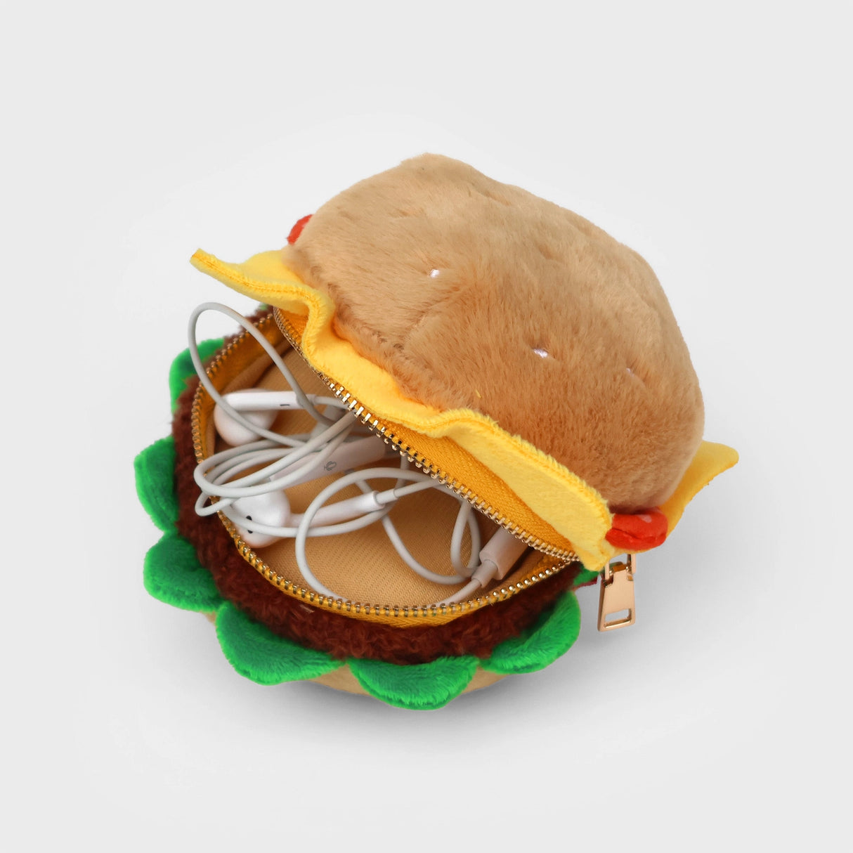 SUCK UK Plush Pouch - Hamburger
Plush burger shaped case with gold zip. Store your belongings amongst the salad and the melted cheese. Yum!
Juicy, tasty, sweet and sour. And very cute. Stuff your stuff into something soft, and squishy. Delicious looking plush zip pouches look like foodie treats but instead of calories, they hold your everyday essentials. From cheesy slices to sickly treats, each pouch is designed to be irresistible and practical. Perfect for pens, cables, cosmetics, or whatever bits and b