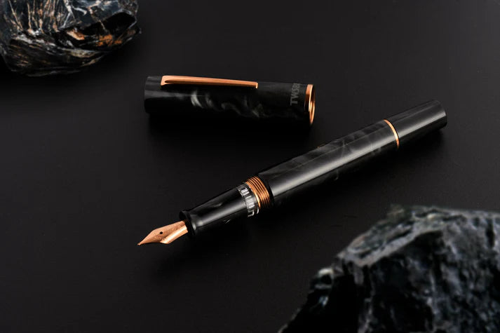 This TWSBI Obsidian fountain pen is made of a dark grey/black swirled acrylic resin, inspired by the natural obsidian stone. The pen is complemented by rose gold-plated trim and is equipped with a rose gold-plated stainless-steel nib.
Pen cap is able to post onto the back of the pen
Piston Filler Fountain pen.
Simply unscrew the end cap, dip into ink, screw back the end cap, and you're done! Ready to write!!