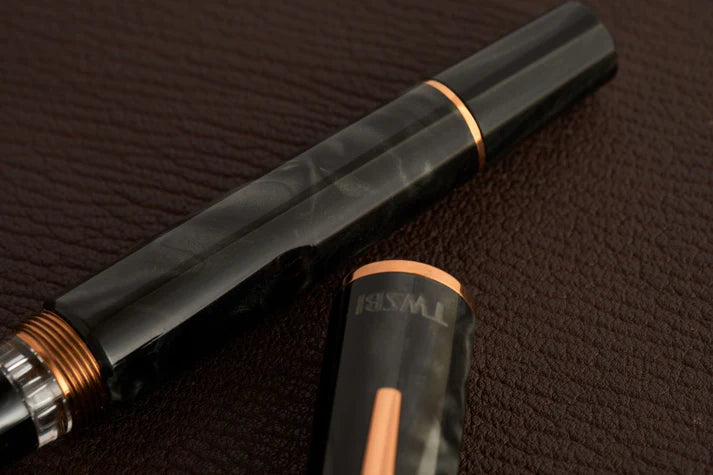 This TWSBI Obsidian fountain pen is made of a dark grey/black swirled acrylic resin, inspired by the natural obsidian stone. The pen is complemented by rose gold-plated trim and is equipped with a rose gold-plated stainless-steel nib.
Pen cap is able to post onto the back of the pen
Piston Filler Fountain pen.
Simply unscrew the end cap, dip into ink, screw back the end cap, and you're done! Ready to write!!