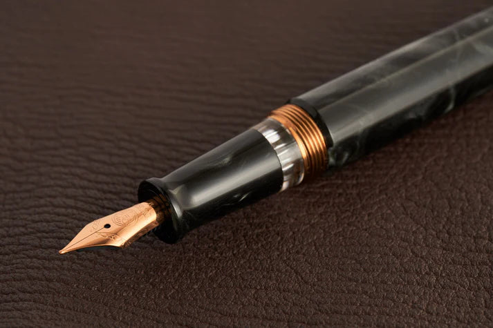 This TWSBI Obsidian fountain pen is made of a dark grey/black swirled acrylic resin, inspired by the natural obsidian stone. The pen is complemented by rose gold-plated trim and is equipped with a rose gold-plated stainless-steel nib.
Pen cap is able to post onto the back of the pen
Piston Filler Fountain pen.
Simply unscrew the end cap, dip into ink, screw back the end cap, and you're done! Ready to write!!