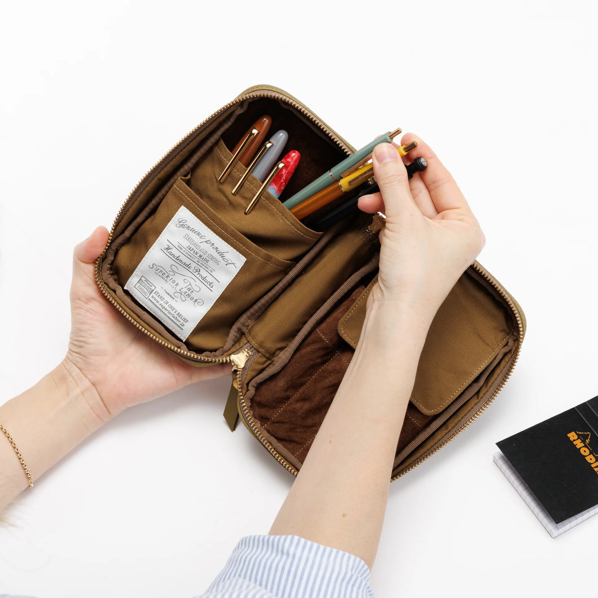 We crafted this leather case for those who love to write —for people who value the quiet moments spent with pen and paper.
Open it up, and on the right side, every surface that touches your precious pens is lined with soft suede, gently protecting them from scratches. On the left, two rows of pockets hold your memo pads, casual pens, or other writing companions, keeping everything neatly in place and ready whenever inspiration strikes.
Size: W13×H20×D4.5cm
About the Leather – Japanese Glove Leather