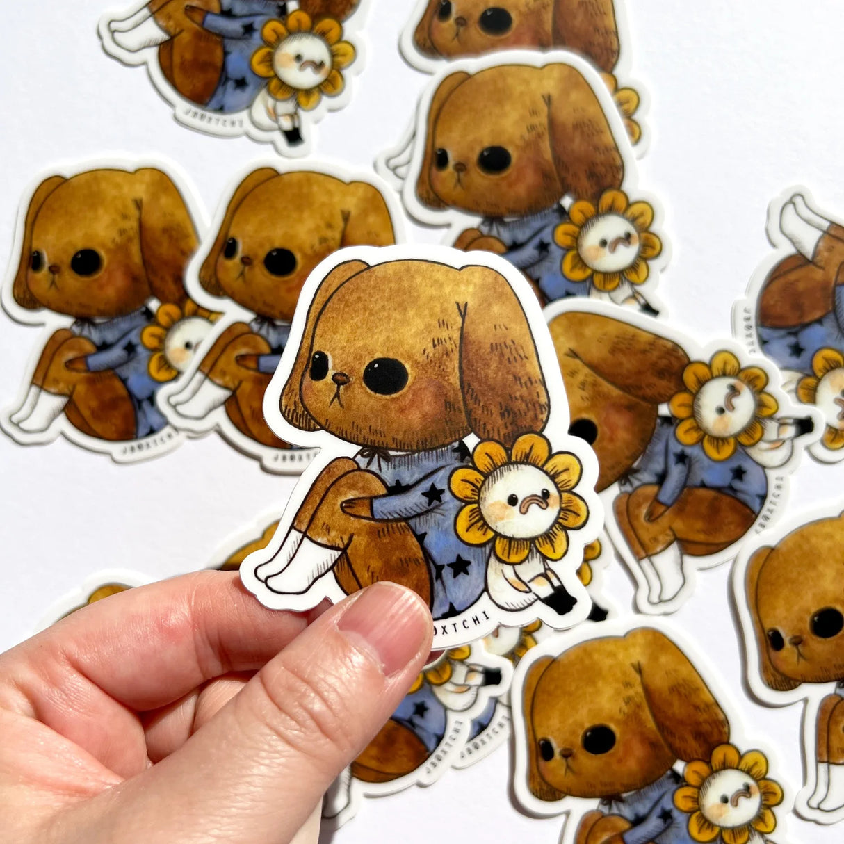 The puppy and flower vinyl sticker was illustrated by jb0xtchi (Jessica Ng). jb0xtchi creates stationary and small trinkets from whimsical ideas in the form of painting using ink, watercolour, and gouache.
Height: 70mm x Width: 60mm
Matte clear laminate coating
100% weatherproof (UV, Water etc)
Scratch resistant & long lasting
Includes 1 sticker 