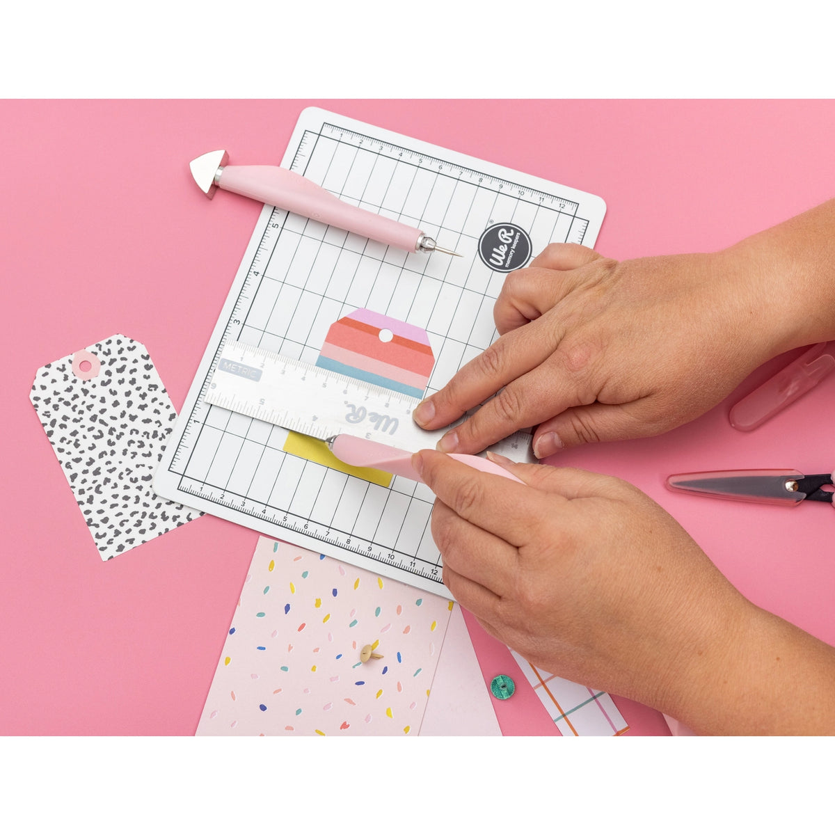 The We R Makers Mini Tool Kit in Pink is the ultimate companion for all your DIY craft projects. This comprehensive kit includes essential tools: a cutting mat, ruler, scissors, craft knife, tweezers, brad setter, and piercing tool. Designed for versatility, it's perfect for scrapbooking, journaling, card making, and a wide range of other crafts.
The vibrant pink color adds a fun and stylish touch to your toolkit, while the high-quality construction ensures each tool is durable and reliable. The cutting ma
