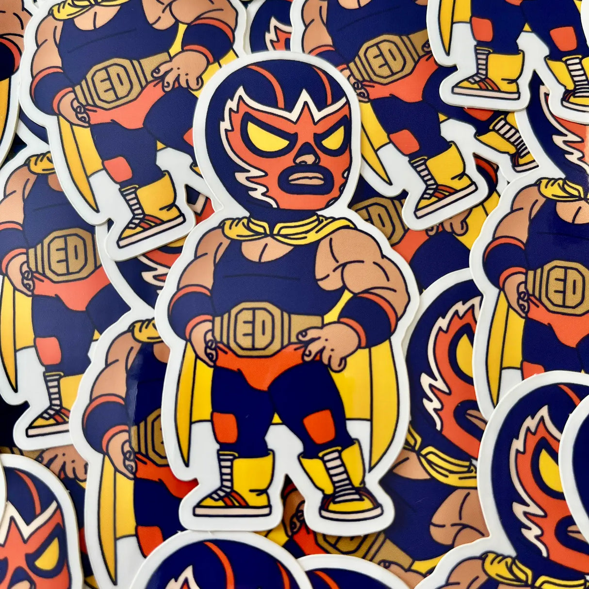 Here is El Diablo, one of our original characters inspired by Mexican pop culture. His real name is Angelo. He is a very shy and polite boy in life, but a real beast in the ring. He is secretly in love with Ina and took up wrestling to impress her, as her father, Great Kitsune, is a famous wrestler.
• Vinyl sticker
• 4.3 x 8 cm
• PVC-free
• UV varnish
• Suitable for outdoor use
• Printed in Sweden