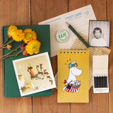 Inspired by Tove Jansson’s beloved world, this collection celebrates the beauty of a slower, gentler way of living where simple pleasures like a warm cup of tea, a quiet walk, and time spent with friends mean everything. Each piece reflects the spirit of Moominvalley: thoughtful, whimsical, and rooted in everyday joy.