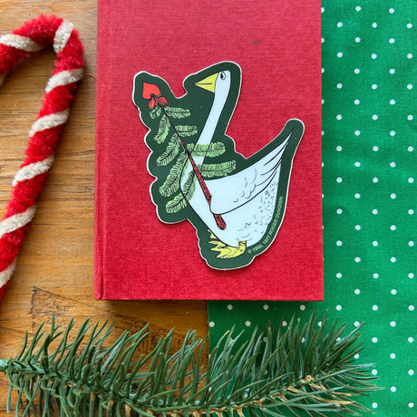 This vinyl sticker features a Petunia® Christmas motif in green tones, proudly made in the U.S.A. from Three Potato Four. Easy to apply to surfaces, it adds a decorative, retro-style touch to gifts and items.