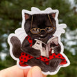 A mystery at the movies? This little black cat can't wait to see how Tuxedo, the famed feline detective, cracks this case!


This 2.5" die-cut gloss vinyl sticker is durable, weatherproof, and perfect for water bottles, notebooks, laptops, bikes, and all sorts of other surfaces! Make sure to clean and dry the surface thoroughly before applying.