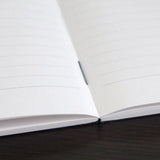 High-quality notebooks are ideal for jotting ideas, taking notes, sketching, making lists, and more. They are perfect for use at home or the office.&nbsp;

It contains white, ruled, acid-free paper.
Comes in a variety of colors, including white, ivory, sky blue, red, aqua blue, green, charcoal, mustard yellow, and navy.
The cover is made from thick, brightly colored specialty paper.&nbsp;
Sturdy thread binding allows the notebook to lay flat, making writing a breeze.&nbsp;
The exterior features a classical 