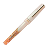 BENU presents the newest Haute Collection — a line of elegant, fashion-inspired pens that blend classic charm with bold, modern flair. The designs include both subtle and vibrant styles, showcasing BENU’s signature glitter and color artistry. Each pen features a faceted body with alternating wide and slender facets, complemented by either gold-plated or chrome-plated trims for a sleek, timeless look.

A mix of golden flakes dances through a soft, pearly pink base, complemented by gleaming gold trim. Tender 