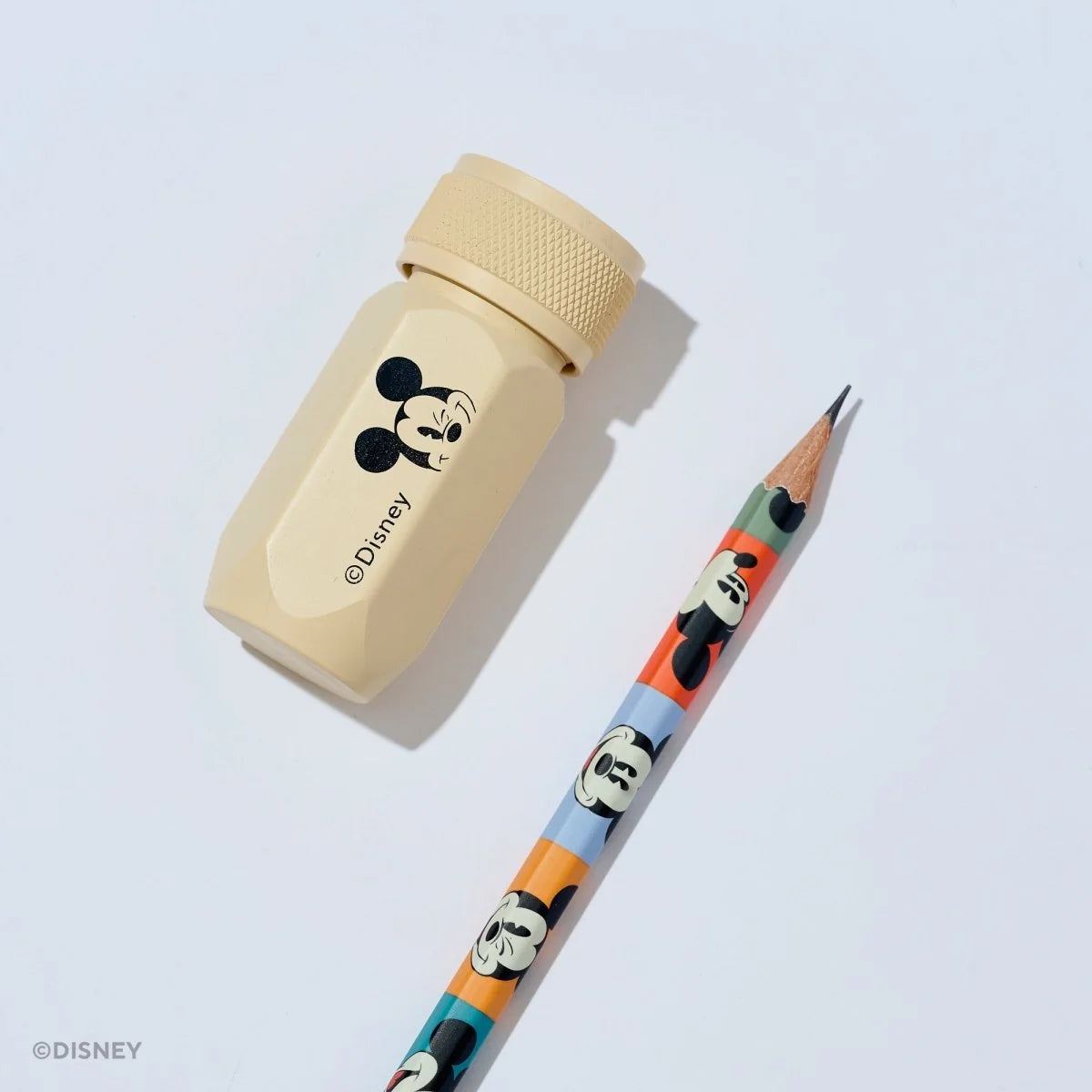 This premium pencil sharpener is made of machined aluminum and sharpens your pencils to a strong, curved point. The cream-colored sharpener features a Mickey Mouse illustration and printed Disney logo on the side in black.