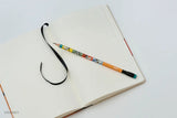 This medium notebook includes 160 pages of 100GSM blank paper and a matte hardcover featuring Goofy and Pluto. It also has a built-in pencil holster that comes loaded with a Goofy Blackwing pencil.