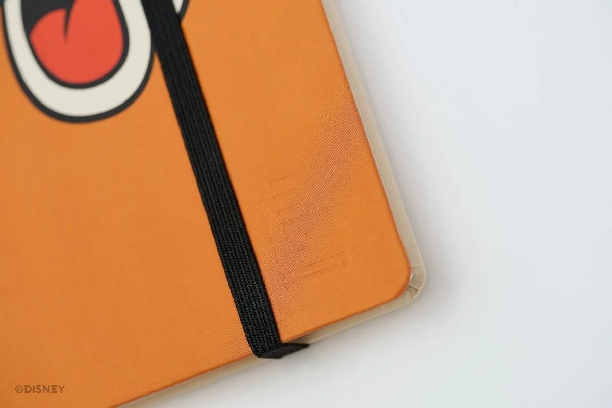 This medium notebook includes 160 pages of 100GSM blank paper and a matte hardcover featuring Goofy and Pluto. It also has a built-in pencil holster that comes loaded with a Goofy Blackwing pencil.