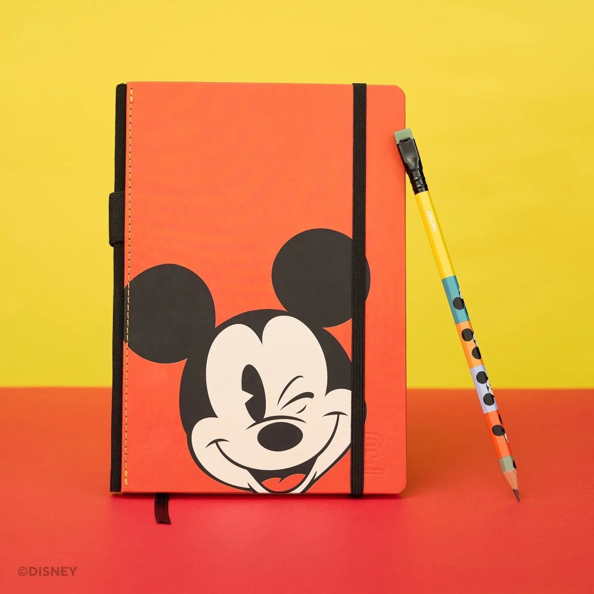 This medium notebook includes 160 pages of 100GSM blank paper and a matte hardcover featuring Mickey and Minnie Mouse. It also has a built-in pencil holster that comes loaded with a Mickey Mouse Blackwing pencil.